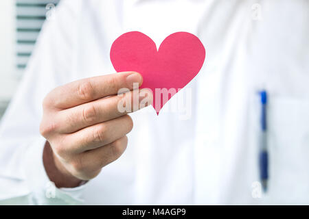 Medico tenendo cuore rosso. Alta pressione sanguigna, attacco di cuore o di malattia concetto. Foto Stock