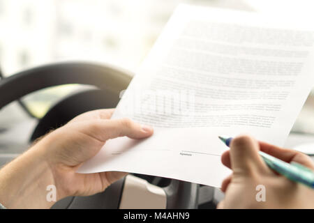 Firma di leasing o di acquisto di auto nuova o usata. Uomo in procinto di scrivere autografo al documento legale. Assicurazione autoveicoli accordo. Contratto di noleggio della carta. Foto Stock