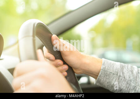Felice uomo alla guida di auto in estate. Autista trattenendo il volante con entrambe le mani. Viaggio su strada di viaggio o di commutare il concetto. Foto Stock