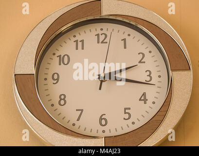 Round orologio da parete mostra il tempo di 2 ore e 15 minuti sul quadrante di luce Foto Stock