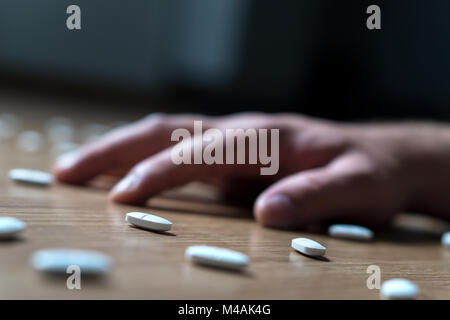 La tossicodipendenza, medico di abuso di sostanze stupefacenti e il gancio e la dipendenza del concetto. Tossicodipendente con sintomi di astinenza sdraiato sul pavimento. Tablet overdose. Premere Foto Stock