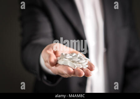 Rappresentante farmaceutica, consulente o testa direttore o manager della società di medicina con medicina bianco e pillole. Uomo in una tuta holding compresse Foto Stock