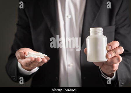 Rappresentante farmaceutica, consulente o testa direttore o manager della società di medicina con compresse di colore bianco. Uomo in una tuta azienda pillole e medicina Foto Stock