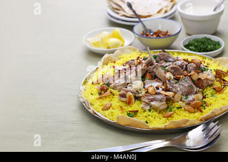 Mansaf è un tradizionale piatto arabo fatto di agnello cotto in una salsa di fermentati yogurt essiccata e servito con riso. Foto Stock