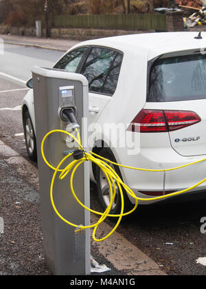 I veicoli elettrici sono diventati un normale vista nelle strade di Oslo Norvegia con molti punti di ricarica, una Volkswagen parcheggiata e-golf con cavo giallo Foto Stock