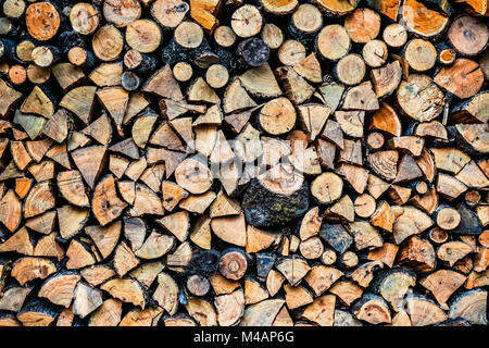 Grande parete di una pila di ciocchi di legna che mostra decolorazione naturale Foto Stock