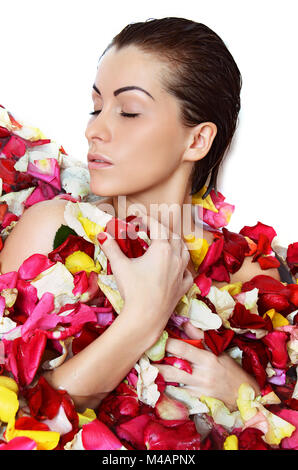 Bella femmina nel bagno con petali di rosa. La cura del corpo. Foto Stock