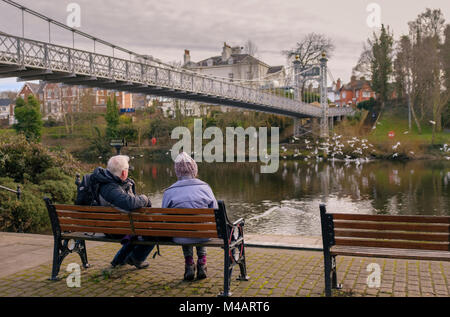 Una coppia di anziani seduti su una panchina con vista del fiume Dee, Chester, Regno Unito. Credito Foto: Brian Hickey/Alamy Foto Stock