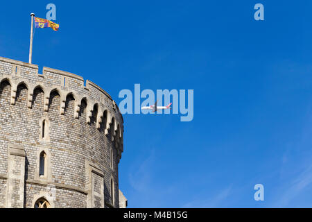 Aerei / aeroplano / aereo / volo dall aeroporto di Heathrow sulla torre rotonda del Castello di Windsor, arrampicata dopo il decollo, & Royal bandiera Standard Foto Stock