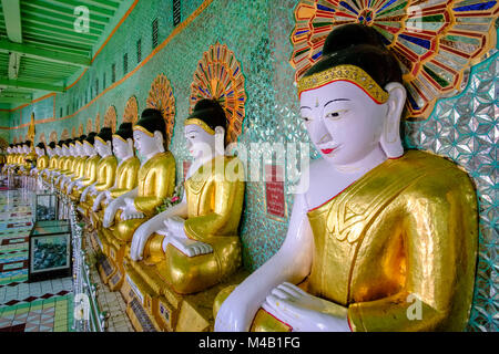 Golden Statue di Buddha sono seduti in una fila all'interno del Umin buddista Thounzeh terrazza sulla sommità della collina Sagaing Foto Stock