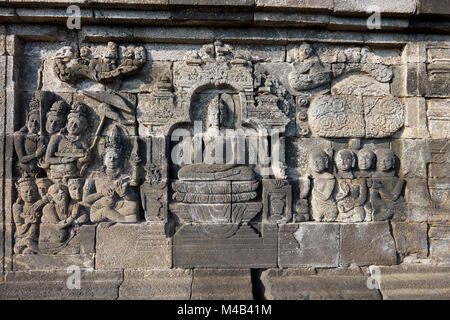 Rilievi su una parete del corridoio. Tempio Buddhista di Borobudur e a Magelang Regency, Java, Indonesia. Foto Stock