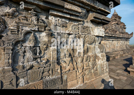 Rilievi su una parete del corridoio. Tempio Buddhista di Borobudur e a Magelang Regency, Java, Indonesia. Foto Stock