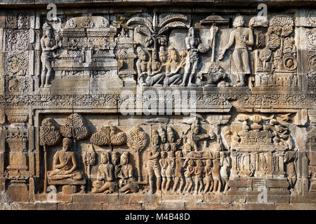 Rilievi su una parete del corridoio. Tempio Buddhista di Borobudur e a Magelang Regency, Java, Indonesia. Foto Stock