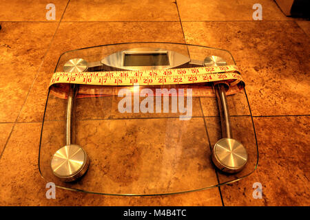 Scala per peso del monitor con un nastro di misurazione Foto Stock