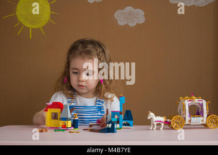 Carino divertente preschooler bambina gioca con la costruzione di blocchi giocattolo costruire una torre in asilo nido stanza. Foto Stock