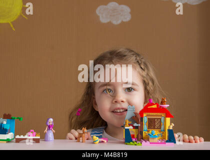 Carino divertente preschooler bambina gioca con la costruzione di blocchi giocattolo costruire una torre in asilo nido stanza. Foto Stock