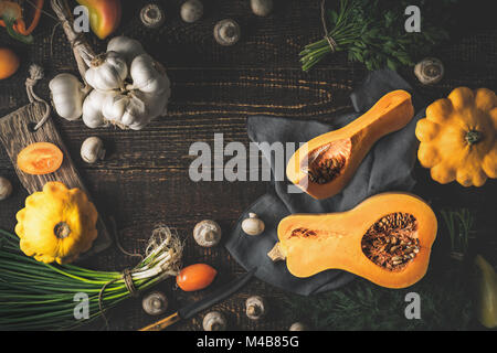 La zucca con diversi ortaggi sul vecchio tavolo in legno Foto Stock