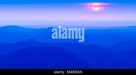 Sunrise picchi di sole attraverso le nuvole sopra la gamma della montagna Foto Stock