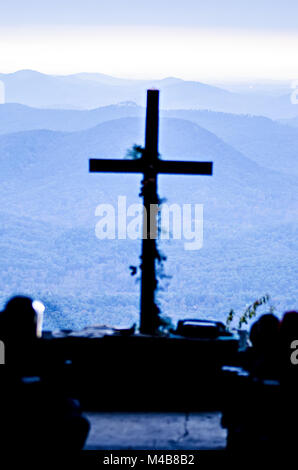 Il culto cristiano croce che affaccia sulle montagne di sunrise Foto Stock