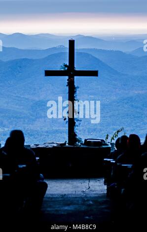 Il culto cristiano croce che affaccia sulle montagne di sunrise Foto Stock