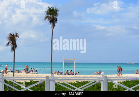 La gente a prendere il sole su una spiaggia tropicale in Cayo Coco, Cuba - una meta perfetta per le vacanze nei Caraibi. Seascape con palme, persone, mare e spiaggia. Foto Stock