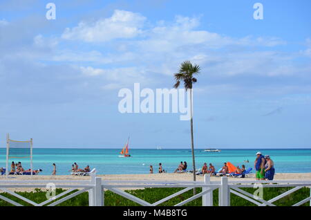 La gente a prendere il sole su una spiaggia tropicale in Cayo Coco, Cuba - una meta perfetta per le vacanze nei Caraibi. Seascape con palme, persone, mare e spiaggia. Foto Stock