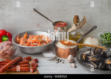 Ingredienti per la paella sul bianco graffiato tavolo orizzontale Foto Stock