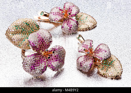 Anello di fatti a mano e orecchini su sfondo di metallo Foto Stock