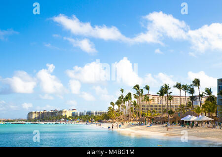 NOORD, Aruba - 14 Marzo 2017: bella vista lungo la zona turistica inPalm Beach ad Aruba con palme, visitatori e sabbia Foto Stock