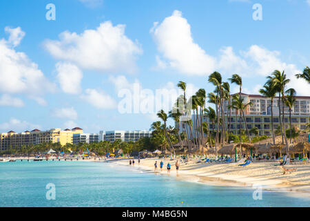 NOORD, Aruba - 14 Marzo 2017: bella vista lungo la zona turistica inPalm Beach ad Aruba con palme, visitatori e sabbia Foto Stock