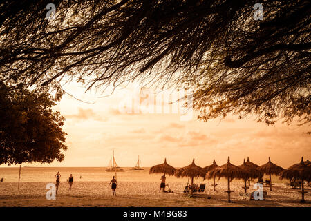 EAGLE BEACH, Aruba - 15 Marzo 2017: Tramonto lungo la bellissima Eagle Beach Aruba con i visitatori e divi divi tree in vista. Foto Stock