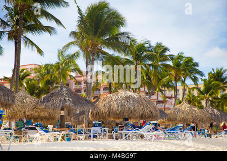 NOORD, Aruba - 14 Marzo 2017: bella vista lungo la zona turistica inPalm Beach ad Aruba con palme, visitatori e sabbia Foto Stock
