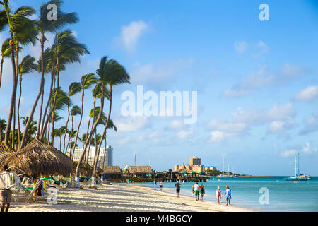NOORD, Aruba - 14 Marzo 2017: bella vista lungo la zona turistica inPalm Beach ad Aruba con palme, visitatori e sabbia Foto Stock