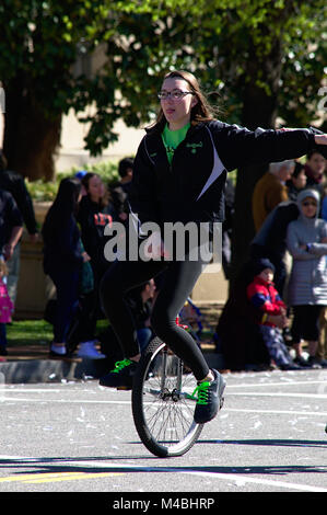 Giovane ragazza vestita di nero e verde monociclo di equitazione in Fiore di Ciliegio Parade di Washington DC Foto Stock