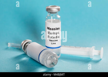 Il morbillo parotite rosolia fiale di vaccino con siringa su sfondo turchese Foto Stock