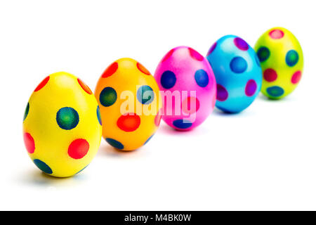 Dipinto di uova di pasqua in fila su sfondo bianco Foto Stock