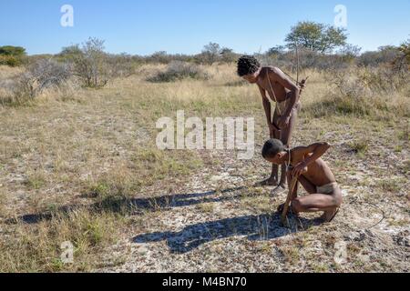 I Boscimani del Ju/' Hoansi-San su tradizionali di caccia con arco e frecce,le piste di lettura,village //Xa/oba,vicino Tsumkwe Foto Stock