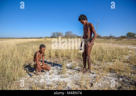 I Boscimani del Ju/' Hoansi-San su tradizionali di caccia con arco e frecce,le piste di lettura,village //Xa/oba,vicino Tsumkwe Foto Stock