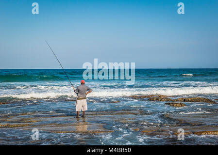 L'uomo la pesca sulla spiaggia Foto Stock