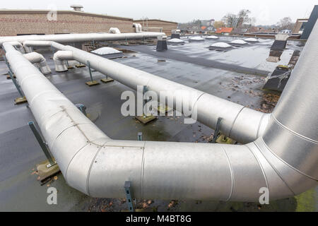 Tubi di ventilazione sul tetto piatto di edificio scolastico Foto Stock