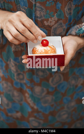 Donna che mantiene eclair nella casella Foto Stock