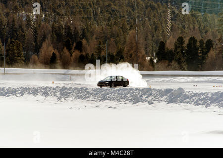 Una vettura sportiva sul ghiaccio velocizzando e bruciando pneumatici in inverno in un nevoso piste di ghiaccio... Foto Stock