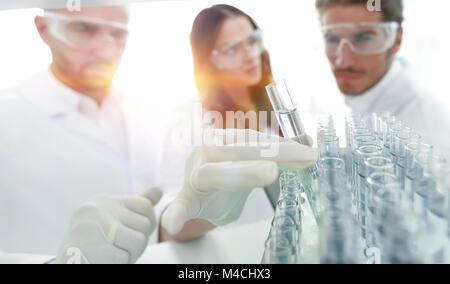 Immagine di sfondo è un gruppo di scienziati che studiano il liquido in Foto Stock