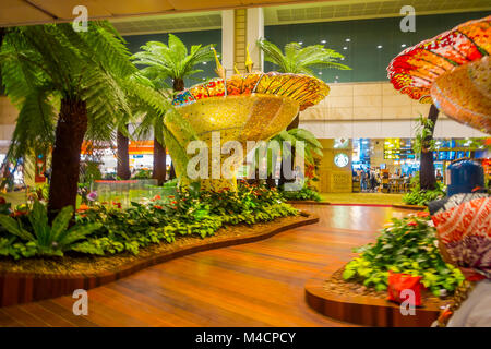 SINGAPORE - circa agosto, 2016: vista interna delle persone che camminano in un piccolo giardino con piante all'interno dell'Aeroporto Changi di Singapore. L'Aeroporto Changi di Singapore è il principale aeroporto civile per Singapore Foto Stock