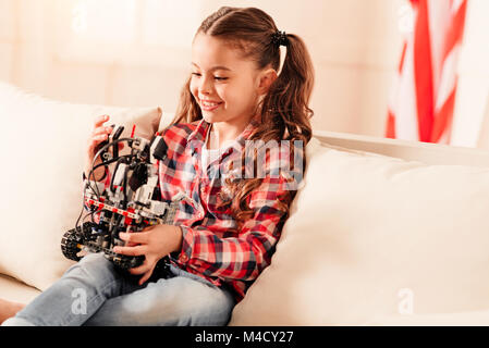 Gioiosa giovane donna sorridente durante il gioco con la macchina robotica Foto Stock