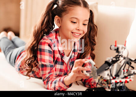 Gioiosa giovane lady in riproduzione casuale con macchina robotica Foto Stock