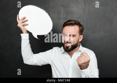 Close up foto di uomo di successo azienda vuoto discorso bolla incoraggiare ad essere motivati e ambiziosi su grigio scuro muro spazio di copia Foto Stock