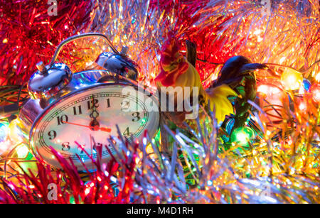 Anno nuovo orologio giacciono in Colorati luminosamente shiny tinsel Foto Stock