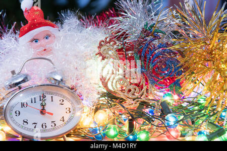 Anno nuovo orologio giacciono in Colorati luminosamente shiny tinsel Foto Stock