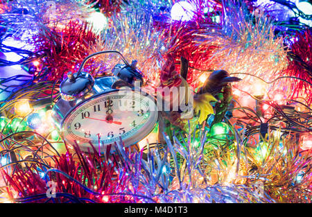 Anno nuovo orologio giacciono in Colorati luminosamente shiny tinsel Foto Stock